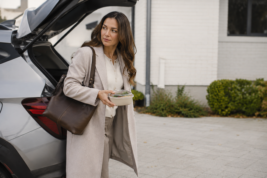 Personne en déplacement avec un sac et un repas facile à transporter près d’une voiture.